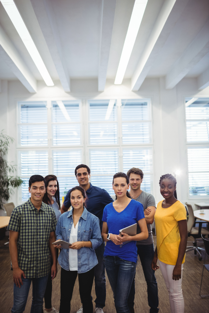 Seven colleagues with tablets in a bright open-plan office