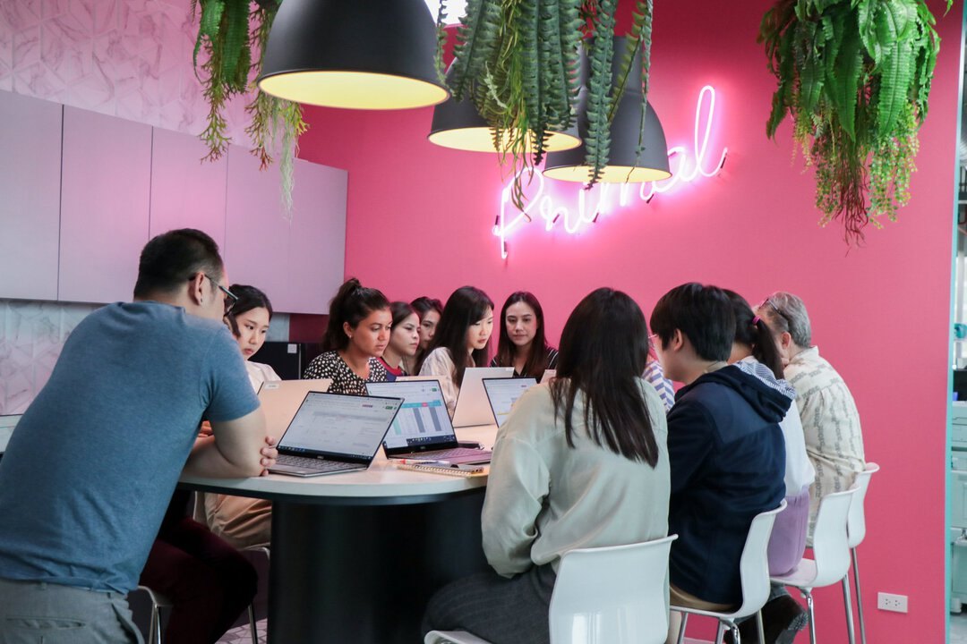 The Primal team meeting in a room with an illuminated Primal sign