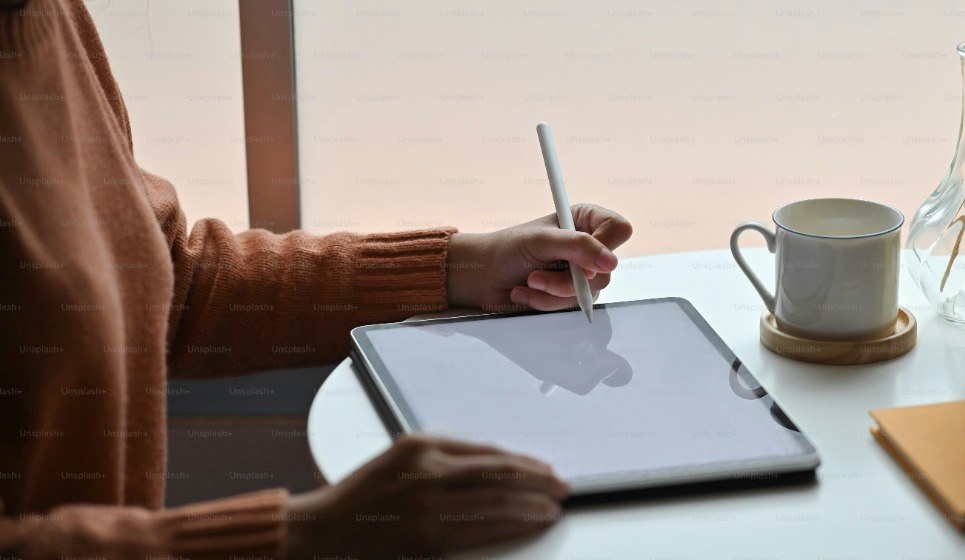 A creative director sketching and designing an ad concept on a tablet