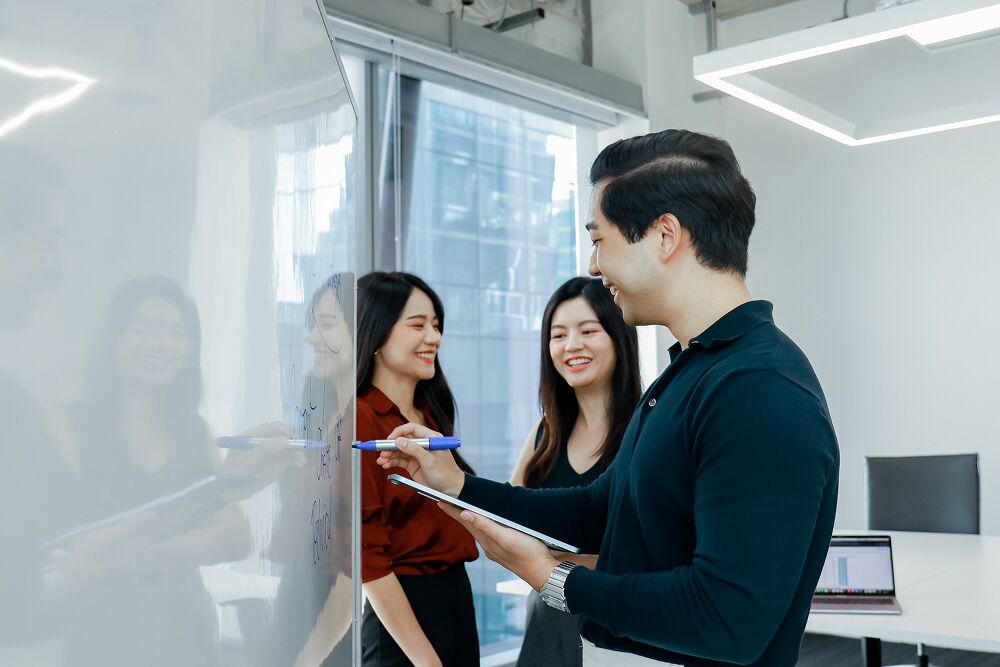 Primal colleagues discussing a brief by the glass wall